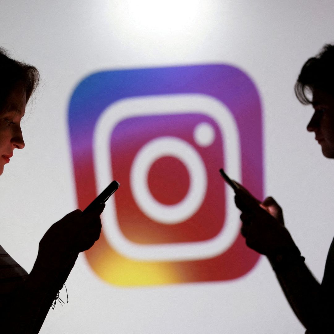 Adolescentes posan para una foto sosteniendo teléfonos inteligentes frente al logotipo de Instagram. Foto: Reuters